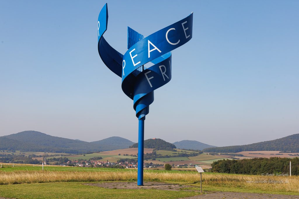 Friedensskulptur, am Alpa Point, blauer Mast mit der Aufschrift Frieden.