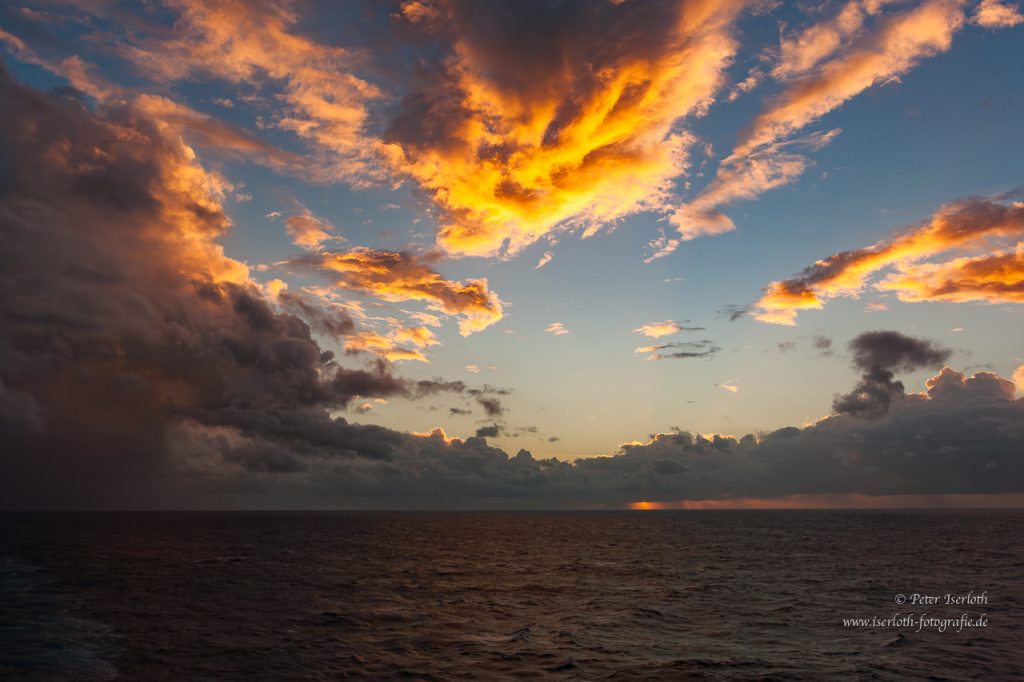 Sonnenaufgang auf dem Nordatlantik, die Sonne kriecht gerade über den Horizont.